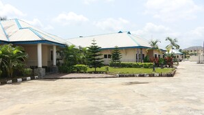A building with a tiled roof and a paved courtyard. - L & L Executive Hotels and Suites (Uyo)