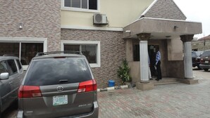 A building with a brick facade, large windows, and a covered entrance with columns. - Labod Hotel (Ibadan)