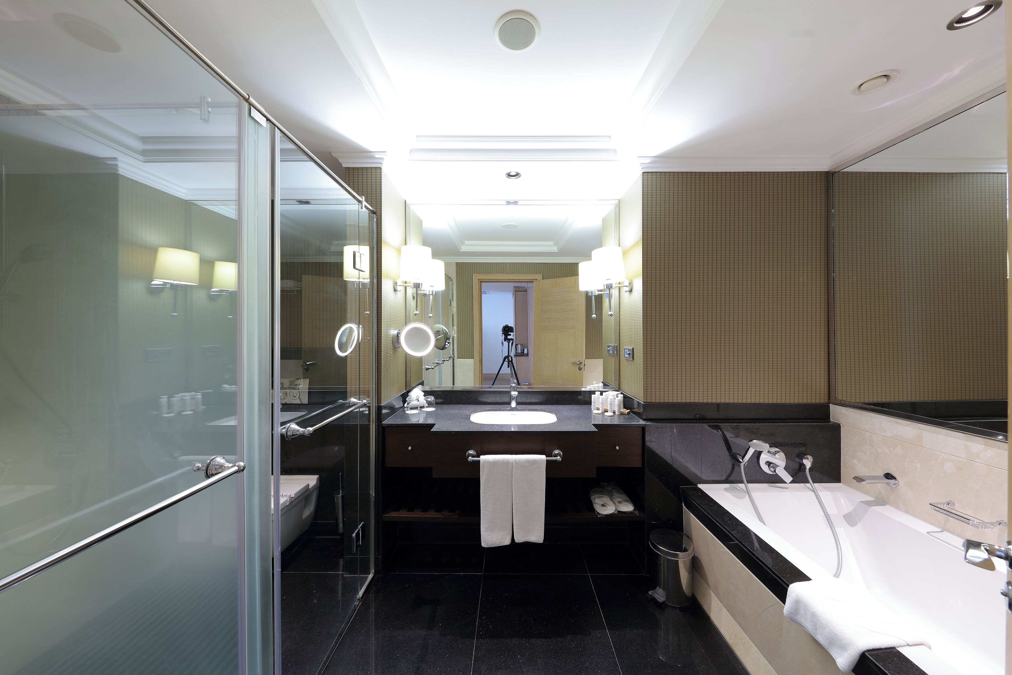 Een moderne badkamer met een douchecabine van glas, een groot wastafel en een vrijstaand bad.