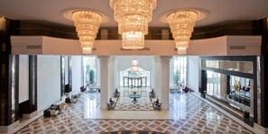 A spacious lobby with a grand chandelier, large windows, and a central seating area. -  Juju Premier Palace - Ultra All Inclusive (Kemer)
