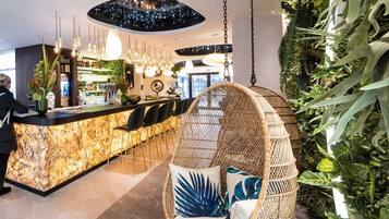 Een modern interieur met een bar, hangstoelen en kamerplanten.