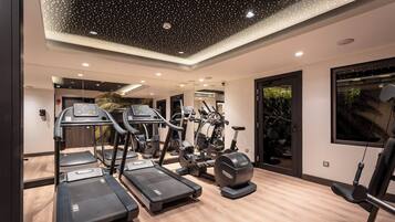 Une salle de sport moderne équipée de tapis de course, de vélos elliptiques et d'appareils de musculation.