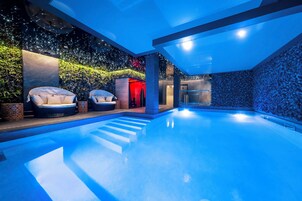 Una piscina techada, sillones reclinables de piscina