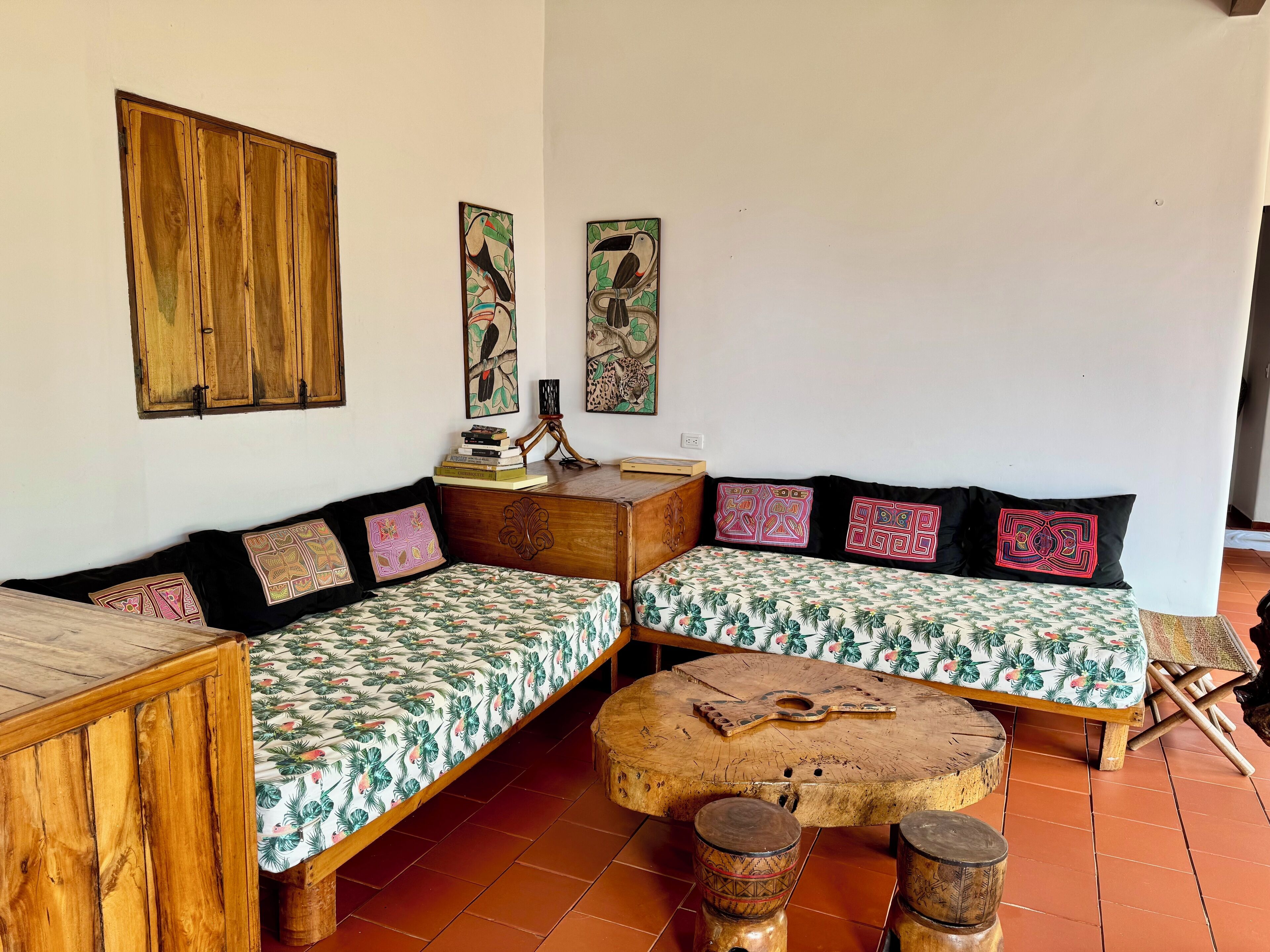 A cozy living area with a wooden sofa set, a coffee table, and a wooden cabinet.