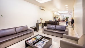 A modern lobby with leather sofas, a coffee table with magazines, and a reception desk. - Almasty Hotel (Chapecó)