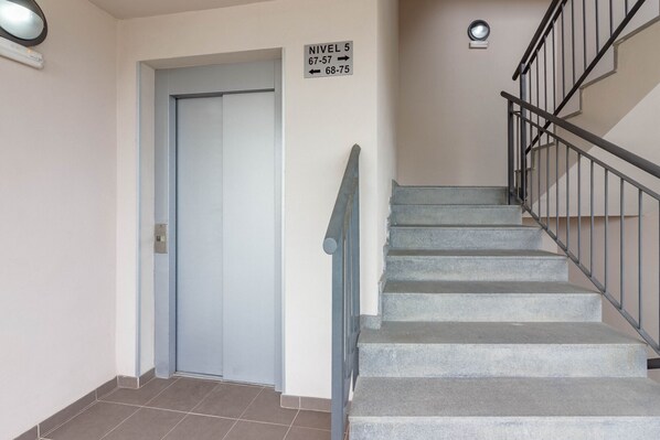 A staircase with a metal railing leading to a door marked 'NIVEAU 5 67-57 68-75'. - EL HORNO 2A008 (Playa Paraiso)