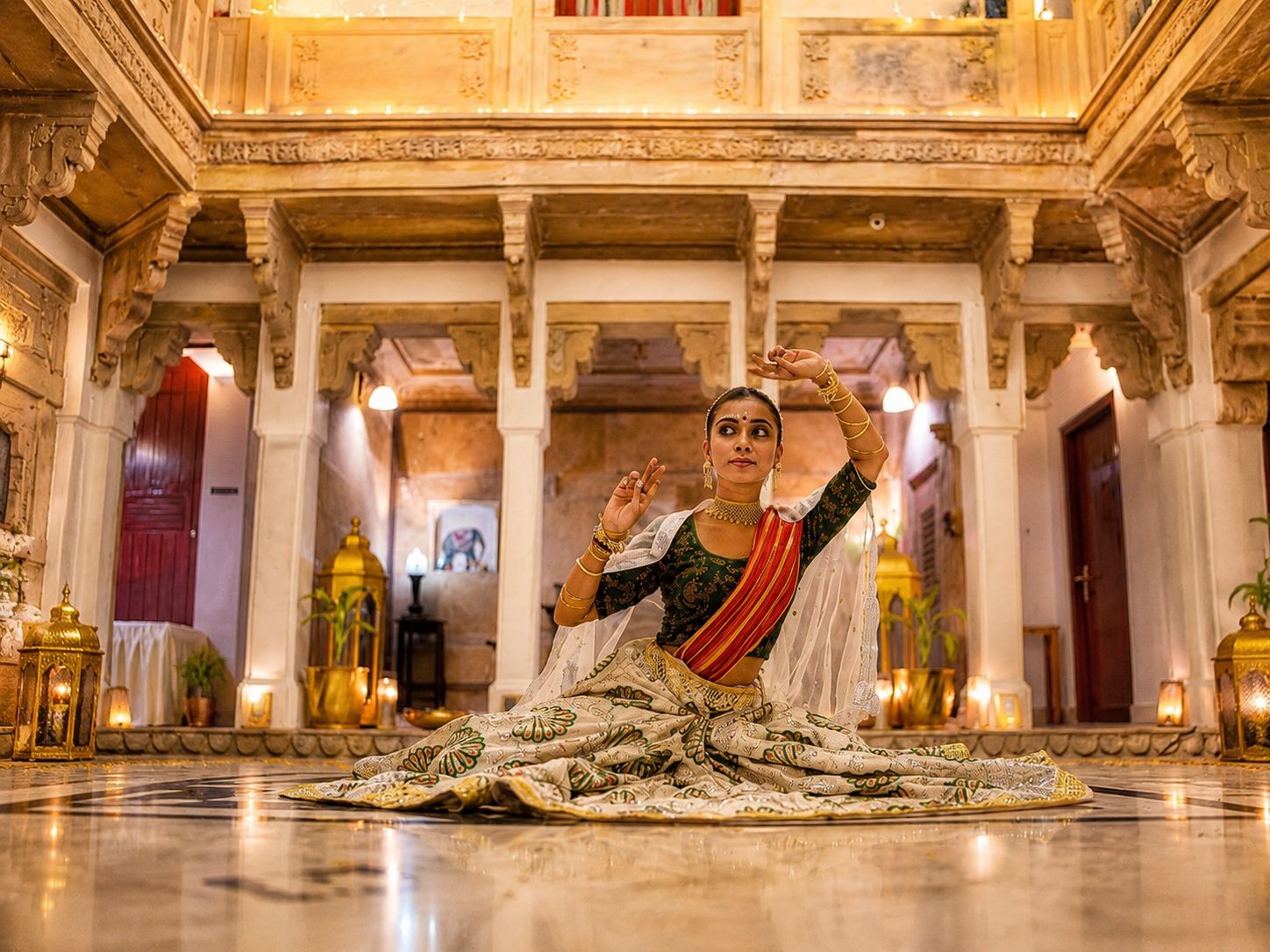 Una persona vestida con traje tradicional sentada en el suelo, en un interior espacioso y ricamente decorado con columnas y candelabros.