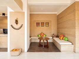 A modern interior with a seating area, a small table, and a decorative wall piece.