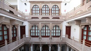 A multi-level building with ornate balconies and arched windows. - Guleria Kothi (Varanasi)