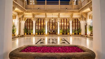 A spacious lobby with a central fountain, columns, and a patterned floor.