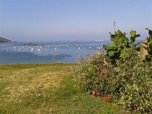 A coastal landscape with a grassy area and a variety of plants. - Charming 3-Star House in Trébeurden, 1km from Sea, Quiet Area, Large Garden (Trébeurden)