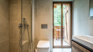 A modern bathroom with a glass-enclosed shower, a toilet, and a large sink. - MOULIN III - Luxury chalet with private hot tub (Les Gets)