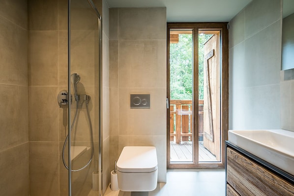 A modern bathroom with a glass-enclosed shower, a toilet, and a large sink. - MOULIN III - Luxury chalet with private hot tub (Les Gets)