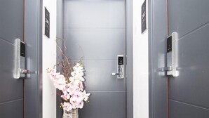 A modern elevator with a digital display, a metallic handle, and a small control panel. - ORA Luxury Rooms (Dubrovnik)