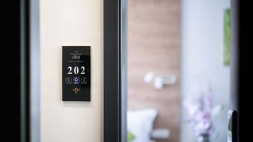 A digital room number display in a hotel lobby, indicating room 202.