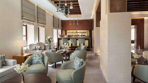 A spacious lobby with a bar area, seating arrangements, and a modern ceiling design. - Souq Al Wakra Hotel Qatar by Tivoli (Al Wakrah)
