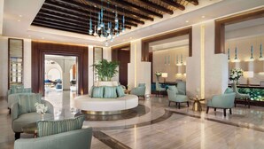 A spacious lobby with a central seating area, modern lighting fixtures, and a polished floor. - Souq Al Wakra Hotel Qatar by Tivoli (Al Wakrah)