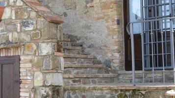 A stone staircase leading to a door with a metal gate.