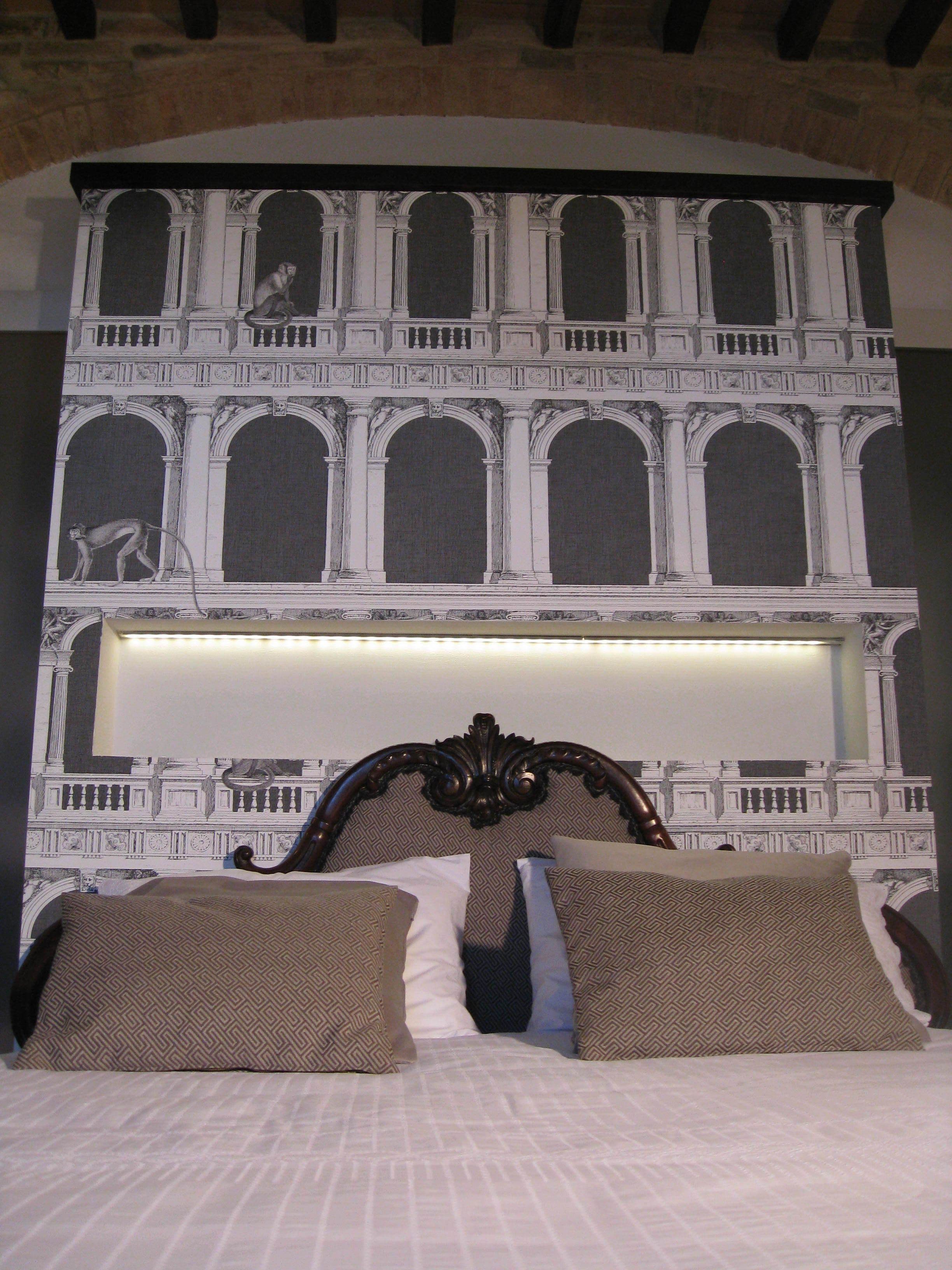 A bed with a headboard featuring a classical architectural design, including columns and arches.