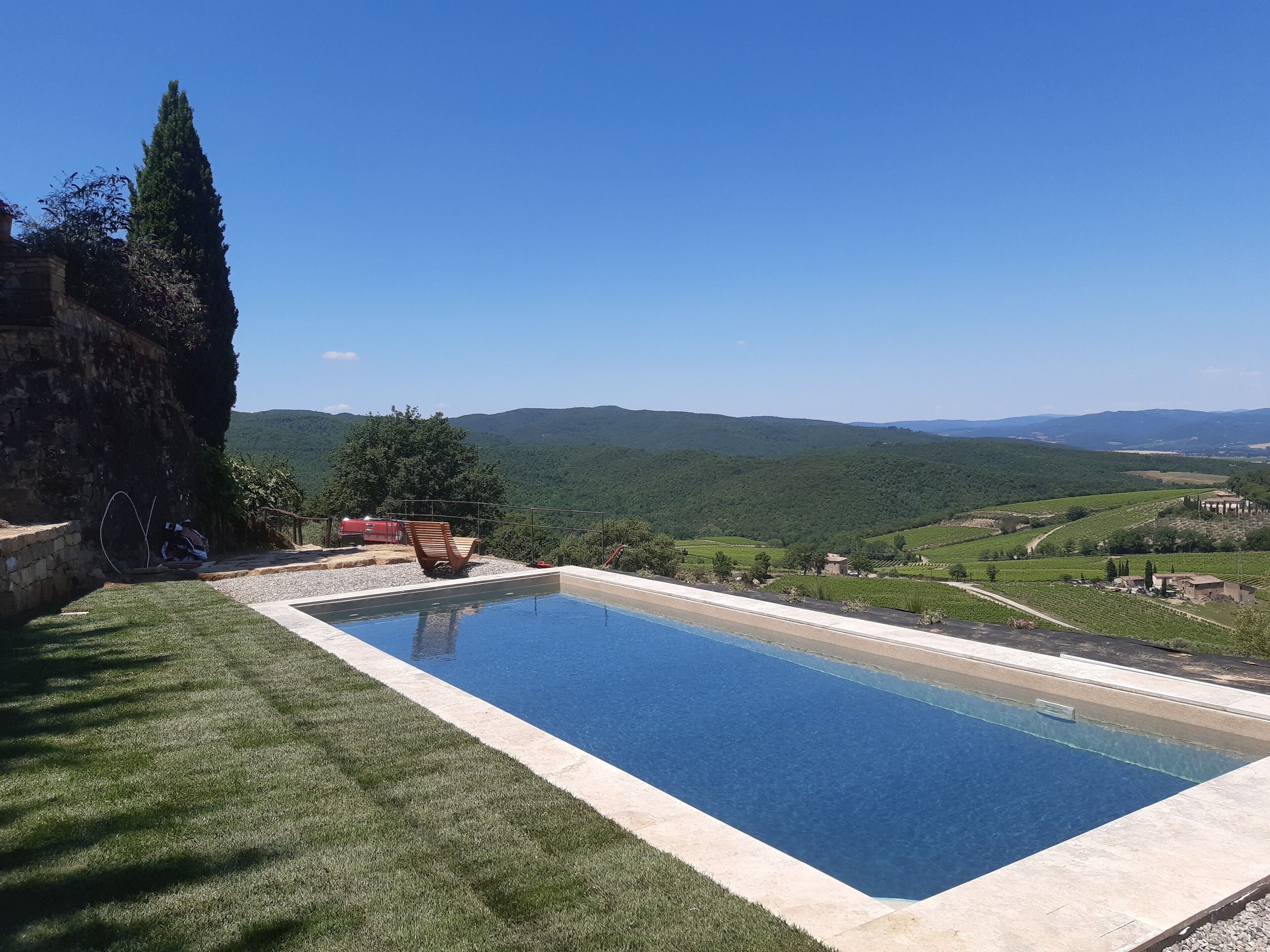 Une piscine offrant une vue dégagée sur le paysage environnant, notamment sur les collines et les vignobles.