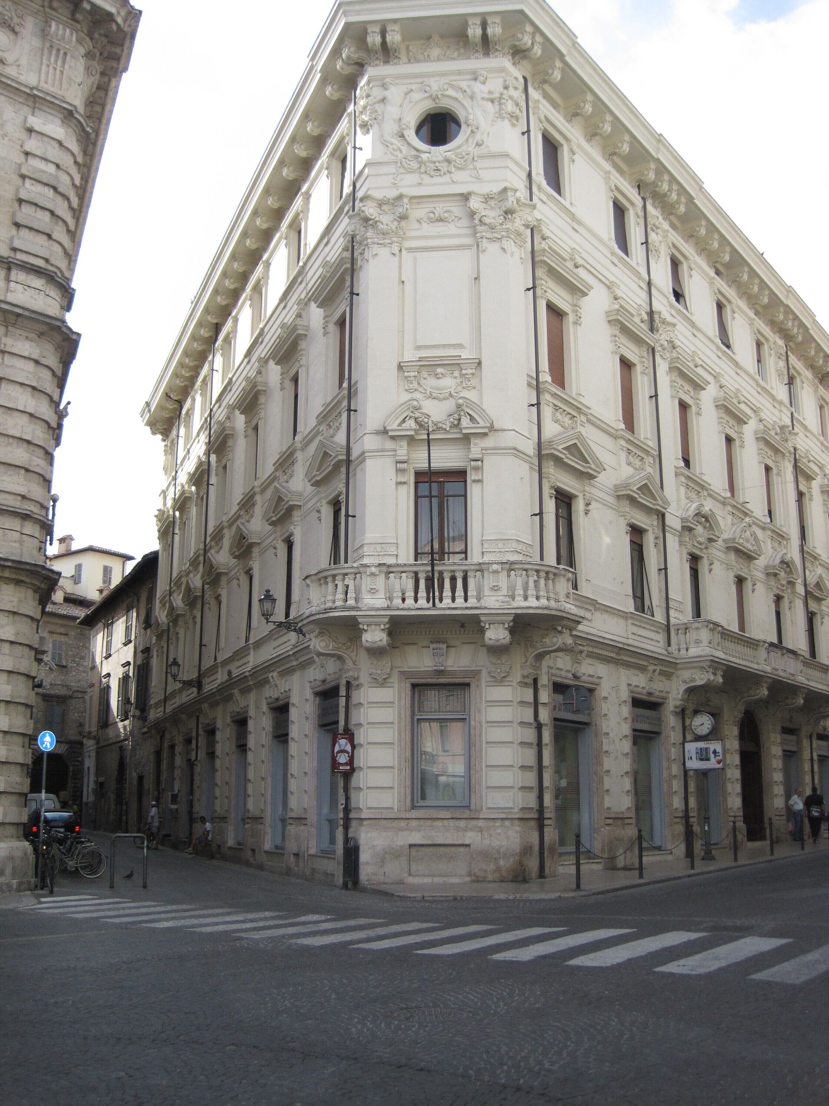 A historic building with ornate architectural details, including a balcony and decorative moldings.