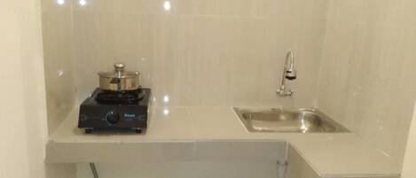A small kitchenette with a sink, a stove, and a countertop.