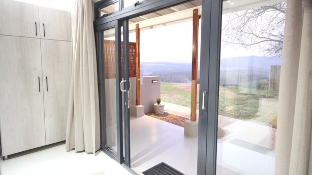 A modern room with a sliding glass door leading to an outdoor area with a view of the countryside. - Curry's Post Bed and Breakfast (Curry's Post)