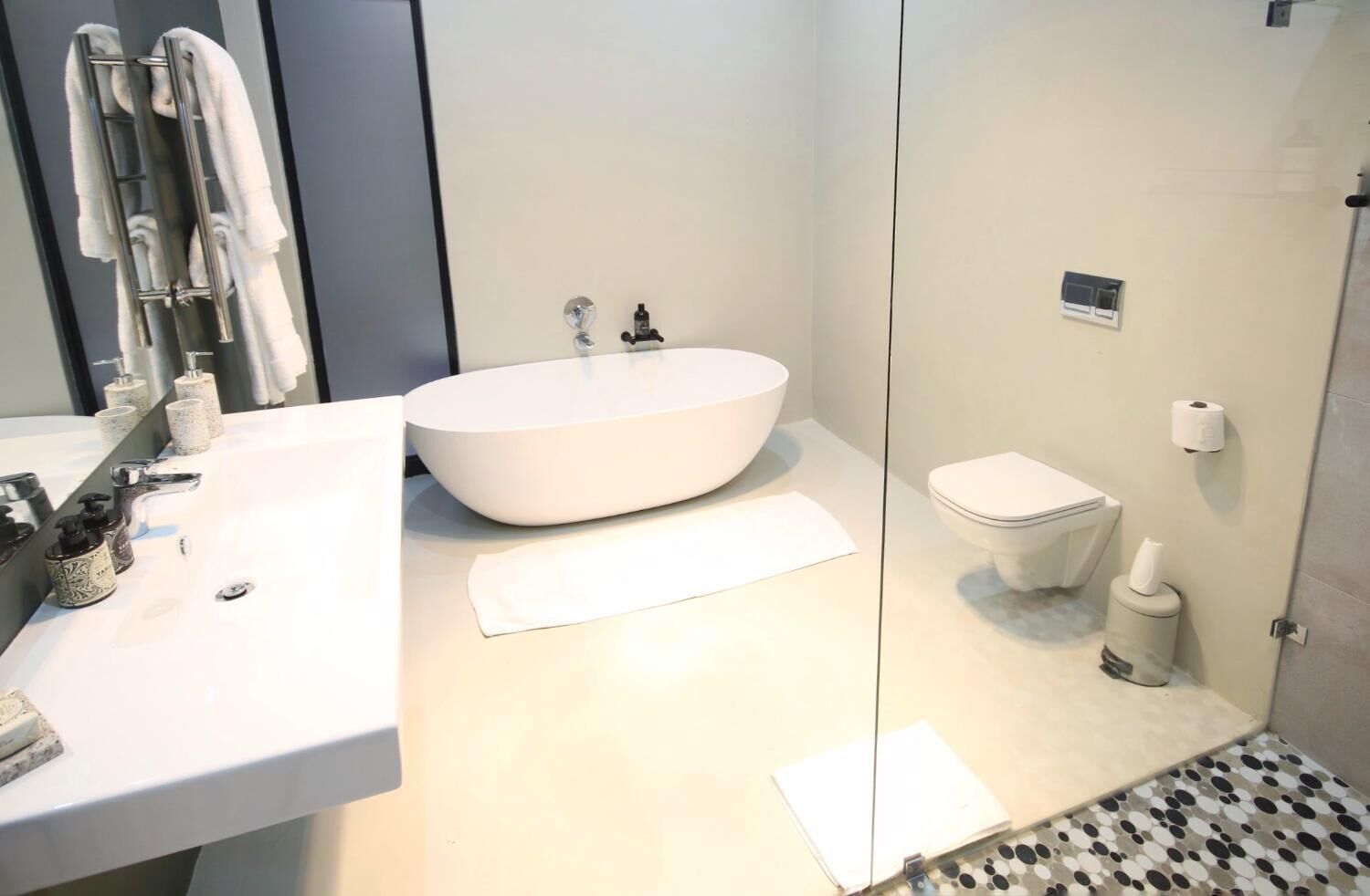 Ein modernes Badezimmer mit einem großen, ovalen Waschbecken, einer Toilette und einer Duschkabine.