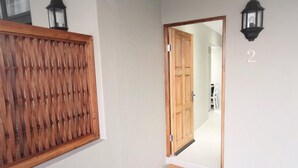A hallway with a wooden door, a number '2' on the wall, and a doormat that reads 'Curry's Post'. - Curry's Post Bed and Breakfast (Curry's Post)