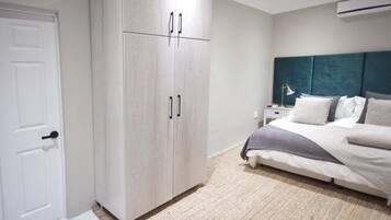 Ein Schlafzimmer mit Bett, Kleiderschrank, Nachttisch und Klimaanlage.