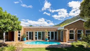A house with a swimming pool, a brick exterior, and a large tree in the yard. - Hout Bay Hilltop - In Cape Town (Hout Bay) (Cape Town)