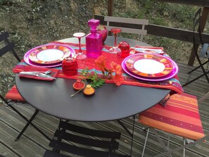 Enjoy a casual outdoor dining experience with a beautifully set table and comfortable seating.