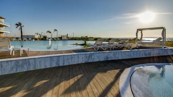 Piscine couverte, piscine extérieure, parasols de plage, chaises longues