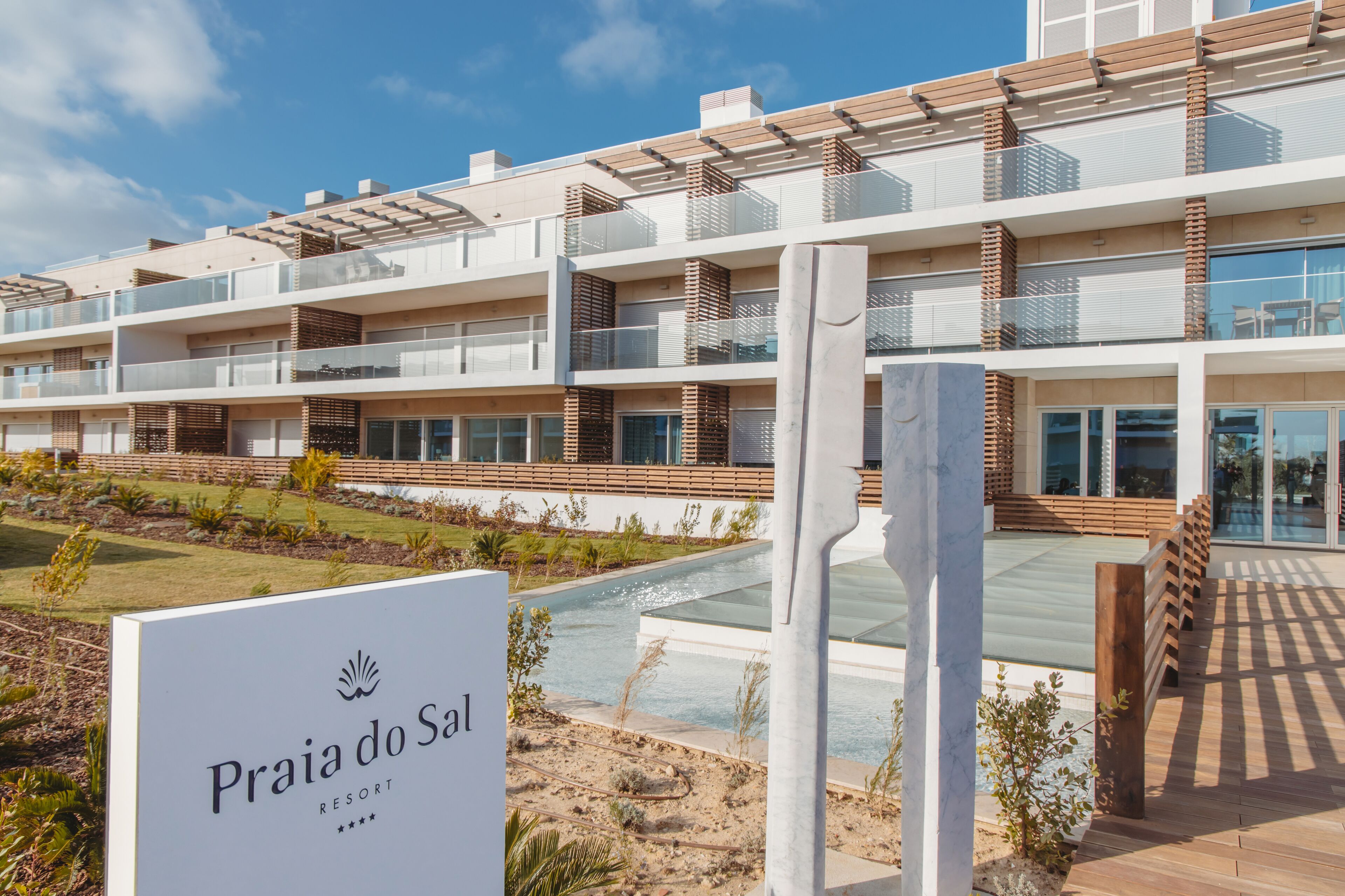 Ein modernes, mehrstöckiges Hotel mit Balkonen, einem Pool und einem Schild, das angibt, dass es sich um das Praia do Sal Resort handelt.