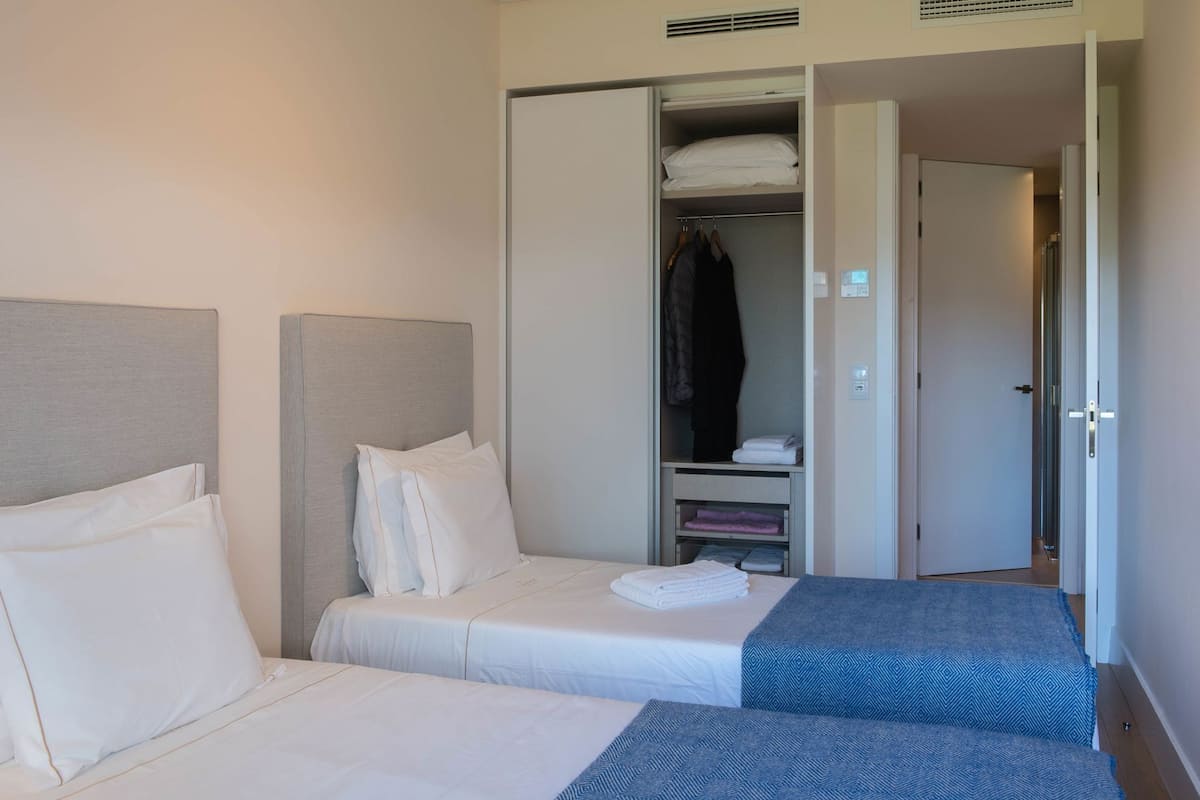 Habitación de hotel con dos camas, un armario y un baño.