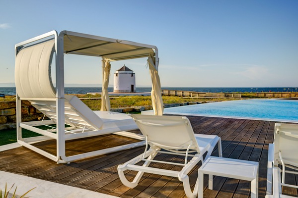 Una piscina techada, una piscina al aire libre, sombrillas