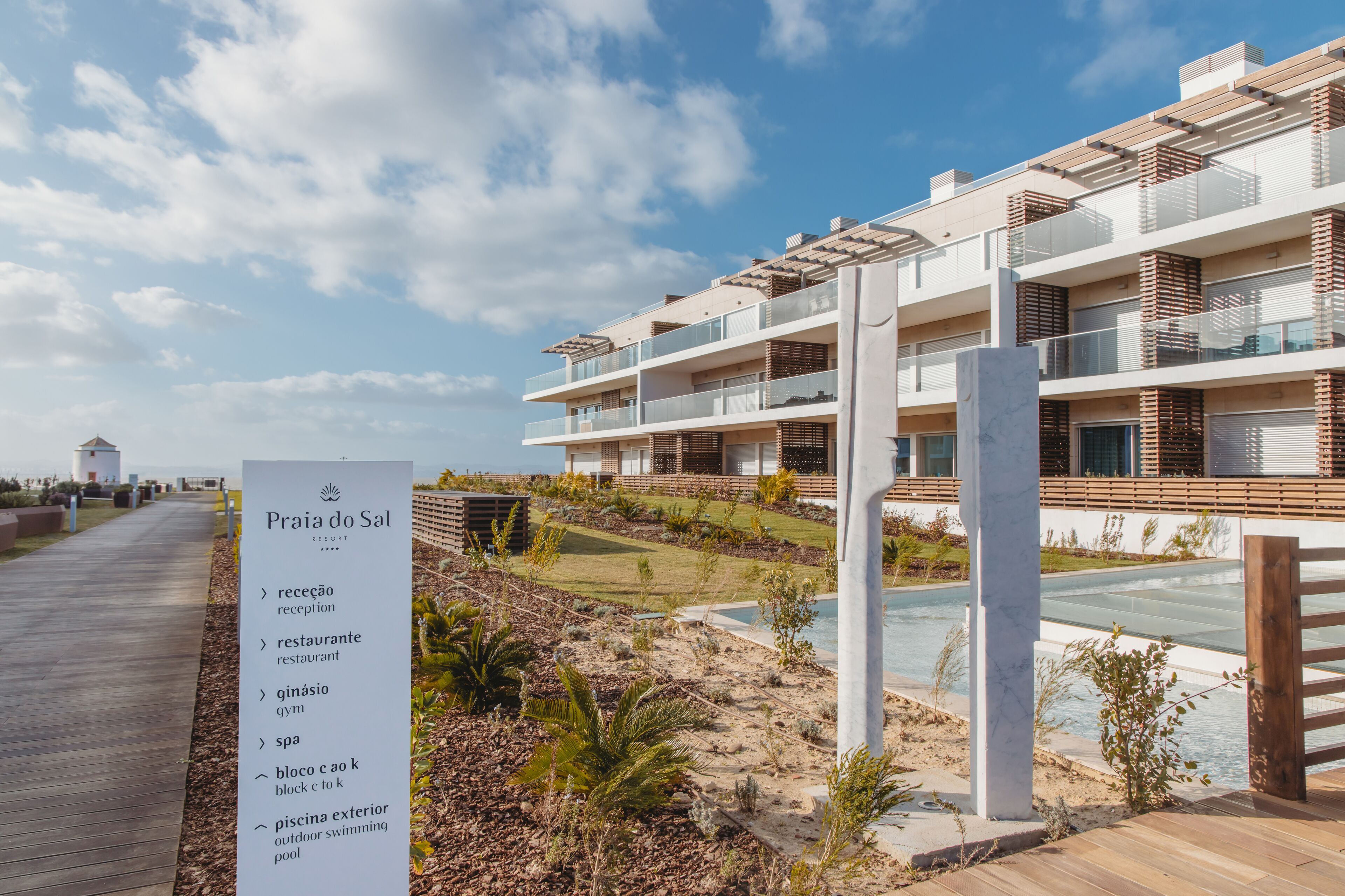 Un hotel moderno con recepción, restaurante, gimnasio, spa y piscina al aire libre.