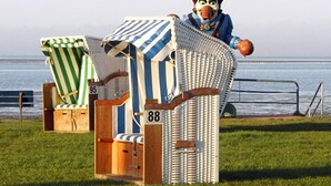 Two beach chairs with numbers 95 and 88, a metal railing, and a view of the sea. - Hotel zur Fischerklause (Butjadingen)