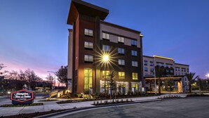 A modern hotel building with a prominent sign for Hampton Inn & Suites by Hilton. - Hampton Inn & Suites San Jose Airport (San Jose)