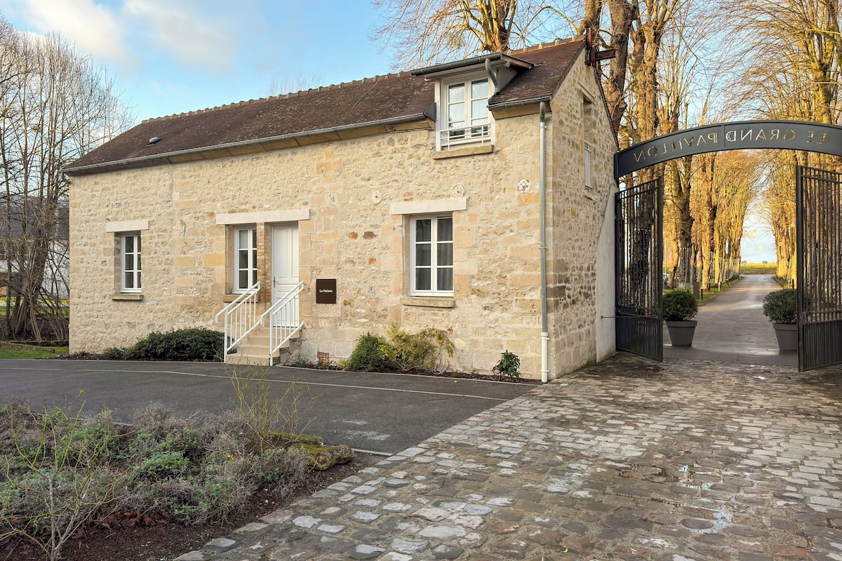 A stone building with a sign reading "Le Malon" and a gate labeled "GRAND PARD".