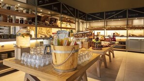 Un comptoir de boulangerie où sont exposés divers produits de boulangerie, ainsi qu’un distributeur de boissons.