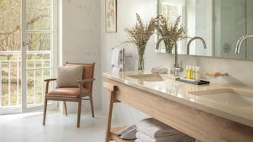 Un bagno con un mobile bagno in legno, uno specchio grande, un lavandino e una sedia.