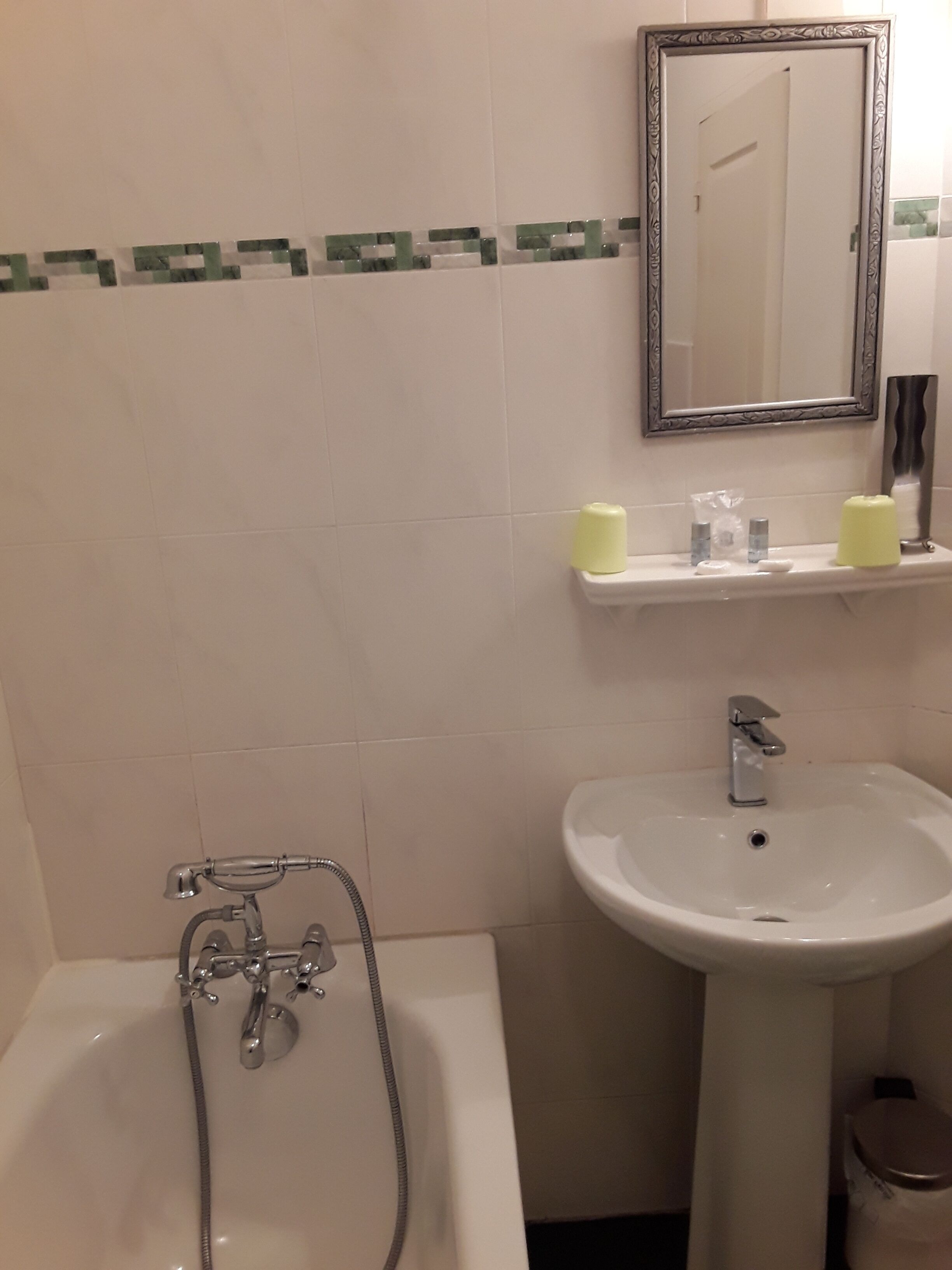 A bathroom with a bathtub, a sink, and a mirror.