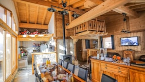 Interior rústico de madera con comedor, cocina y sala de estar.