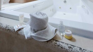 Un baño moderno con una bañera grande, ducha, lavabo y espejo.