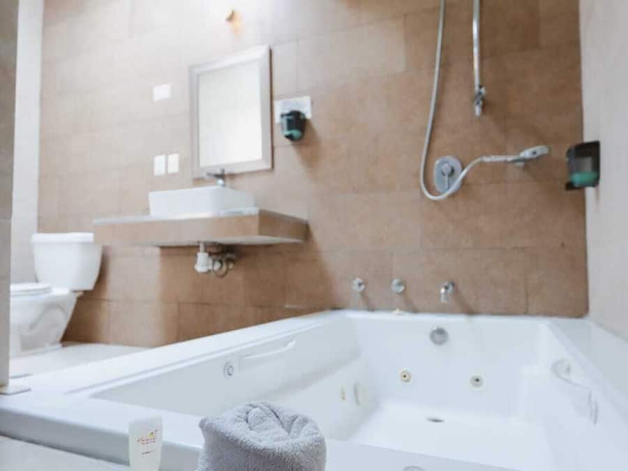 Deluxe Suite, 1 King Bed, Hot Tub | Bathroom | Combined shower/tub, free toiletries, towels, soap