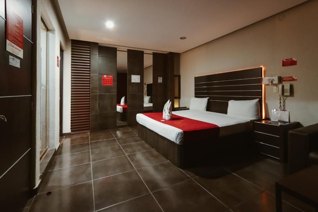 A modern hotel room with a large bed, a bedside table, and a wardrobe.