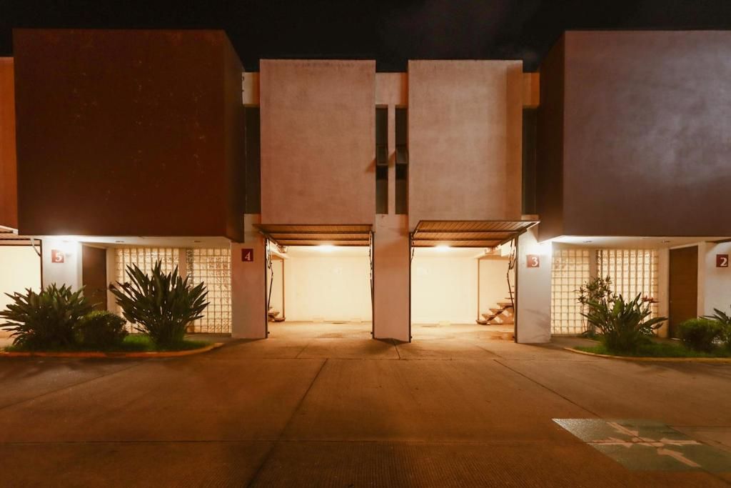 A building with multiple parking spaces and a central entrance.