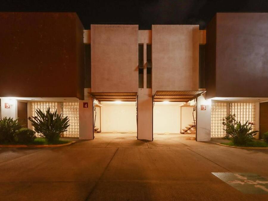 A building with multiple parking spaces and a central entrance.