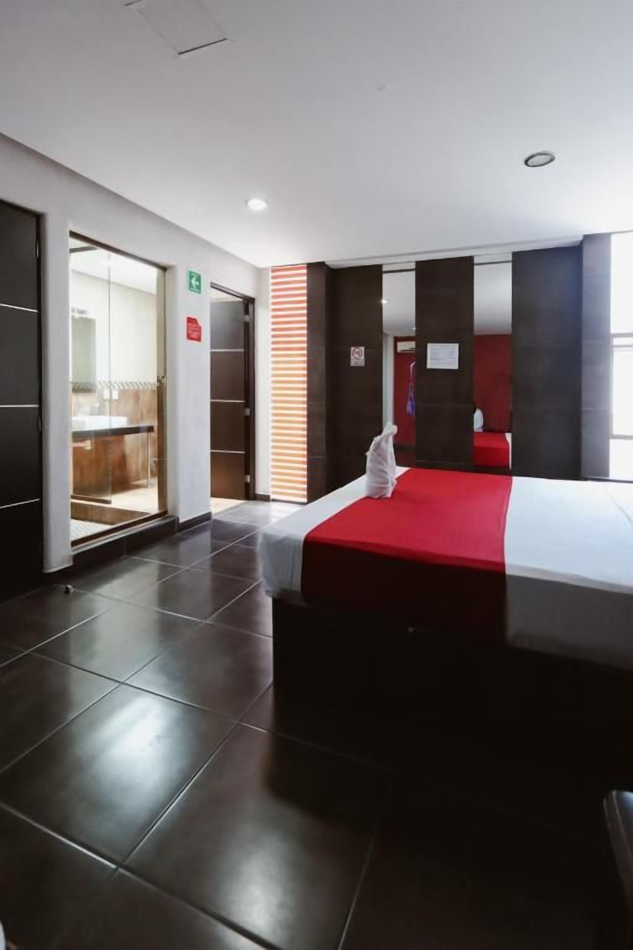 Quarto de hotel com cama, um guarda-roupa e porta para um banheiro.